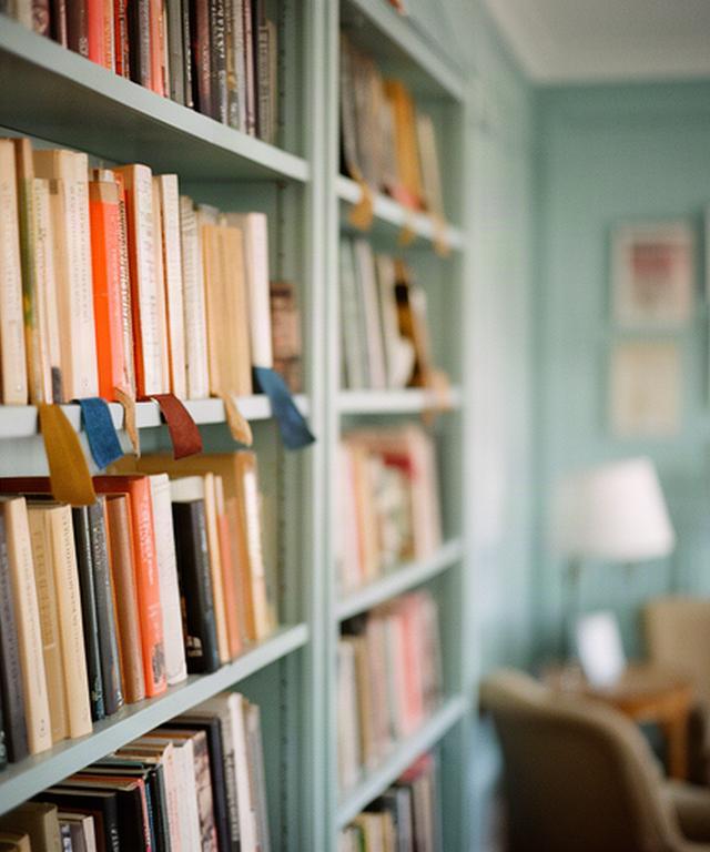 Scaffali pieni di libri in una sala di lettura, con segnalibri colorati tra i volumi